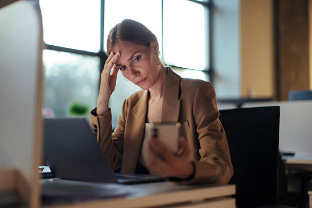 A woman pausing at her laptop during a demanding day